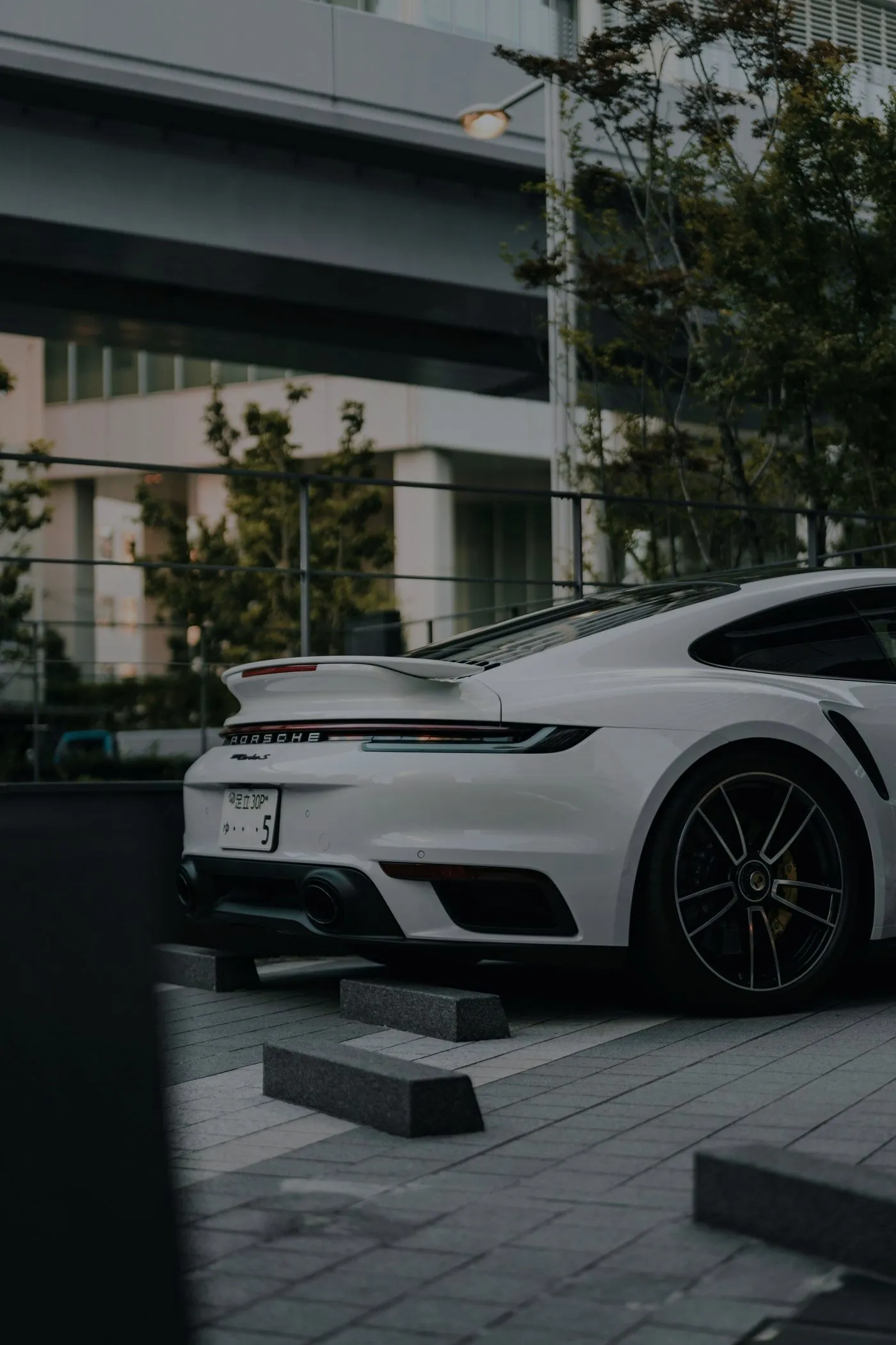 Porsche 911 Turbo S bianca da dietro, con ala estesa e barra luminosa